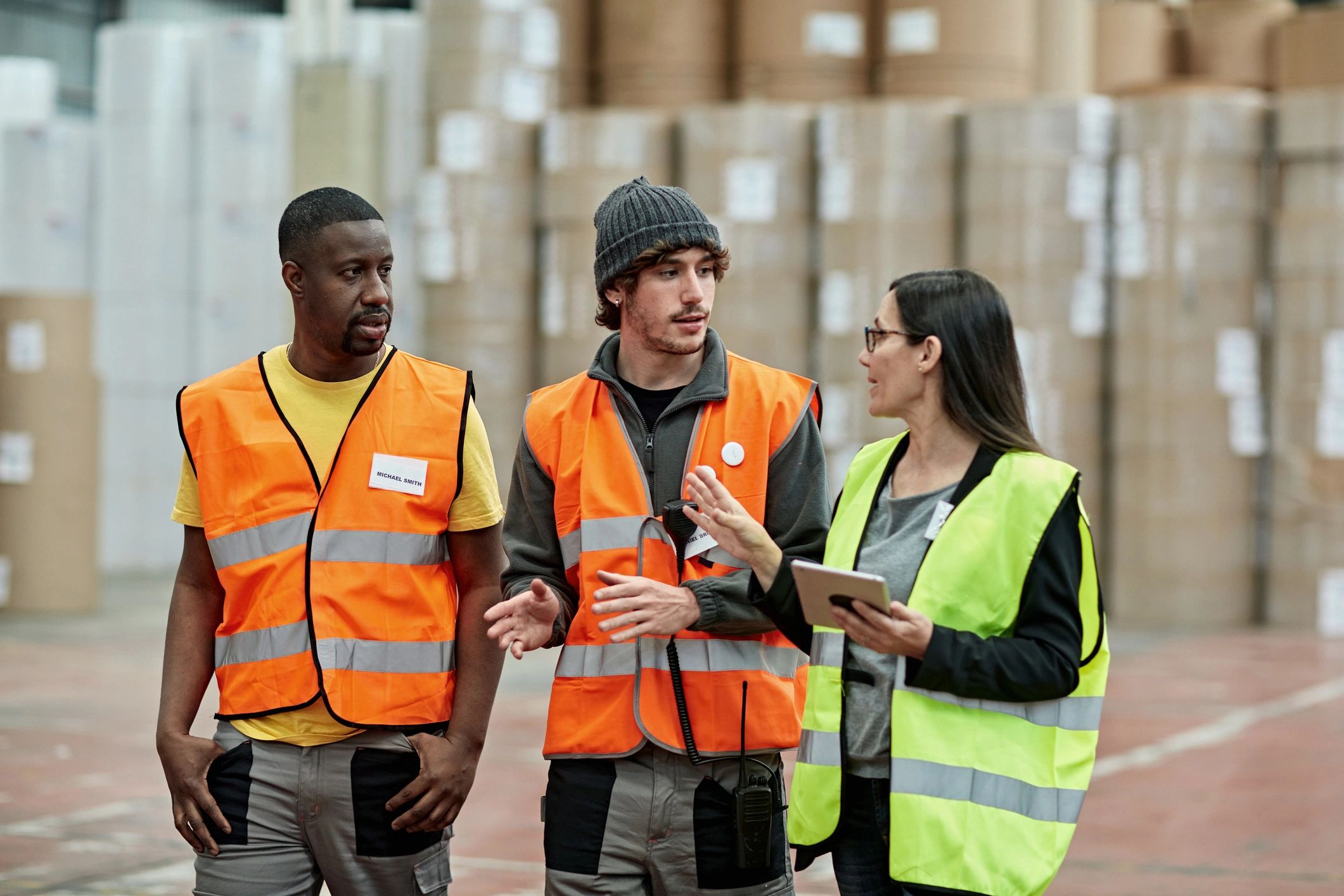 Warehouse supervisor discussing plans with workers in reflective vests