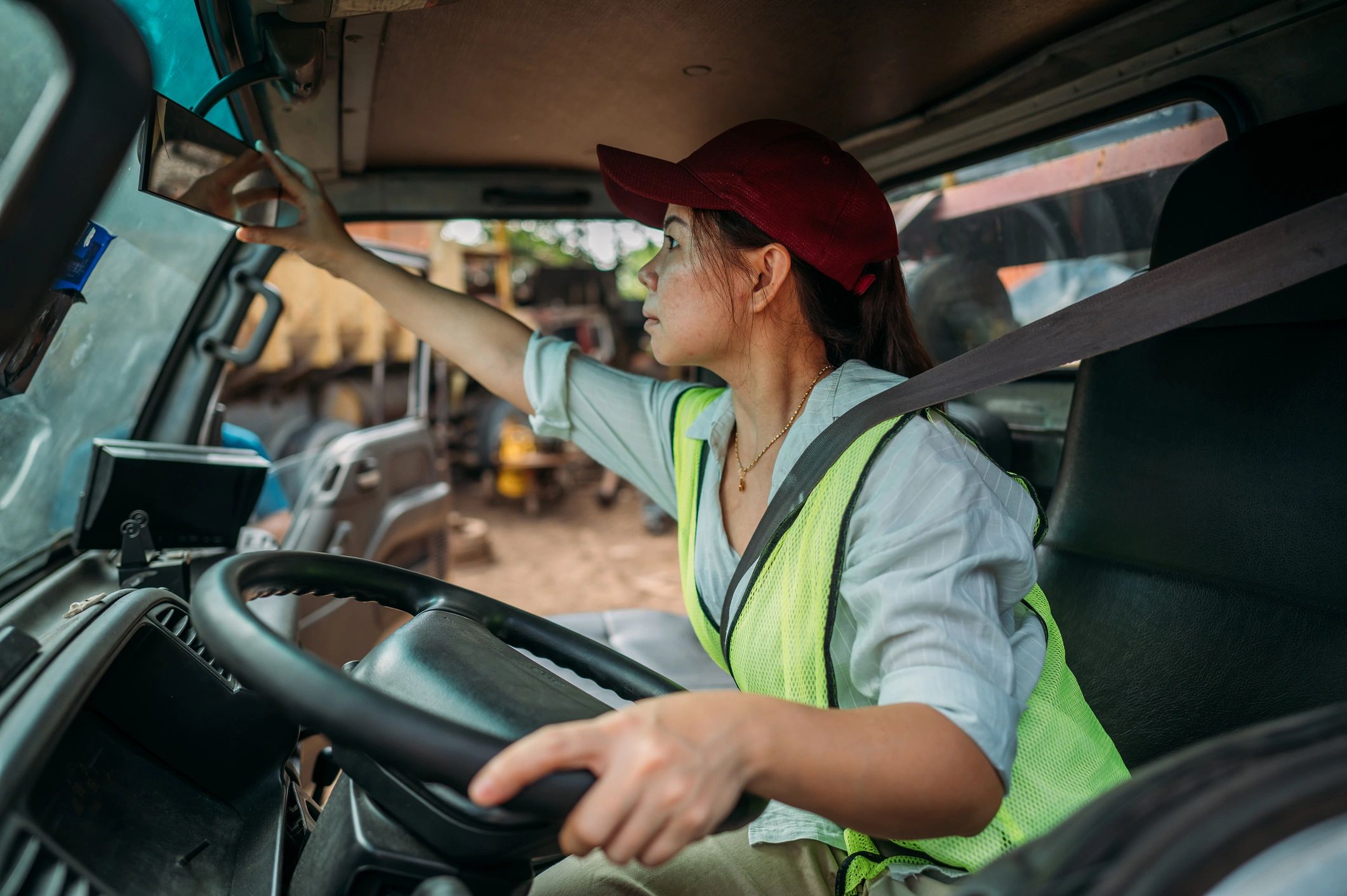 Delivery driver in reflective vest seated in vehicle preparing to depart
