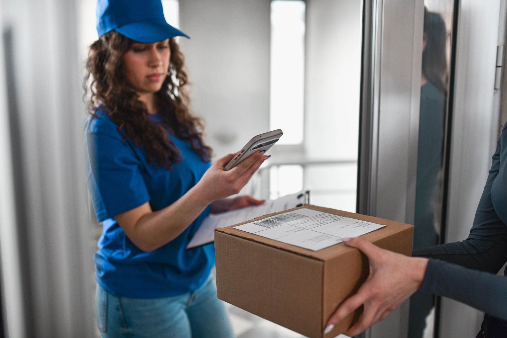 Delivery driver scanning a package at a doorstep